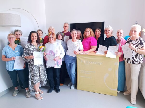 Auf dem Bild sichtbar der Kurs für Ehrenamtliche Hospizbegleiter aus dem Jahr 2026 mit 14 Ehrenamtlichen. Ein Gruppenbild mit allen Ehrenamtlichen, Geschäftsführerin Christine Gundacker und Koordinatorin Katrin Reinhardt. Das ist aufgenommen im Seminarraum in der Kreuzstraße 2 in Ludwigshafen Friesenheim 